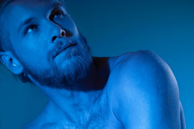 Blanke man zonder shirt in blauwe tinten