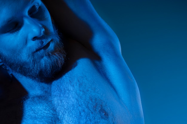 Blanke man zonder shirt in blauwe tinten