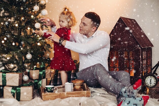 Blanke vader helpt haar dochter om de kerstboom te versieren