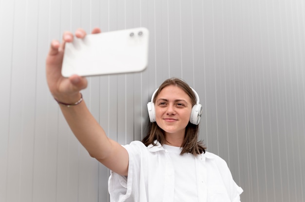 Gratis foto blanke vrouw die een selfie maakt met haar smartphone