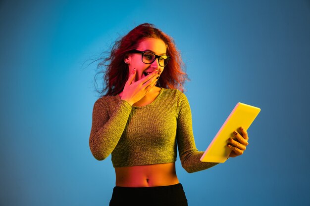 Blanke vrouw portret geïsoleerd op blauwe studio in neonlicht