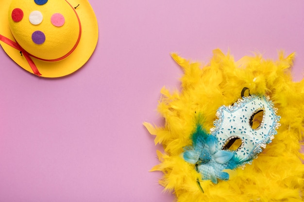 Blauw Carnaval-masker met gele veerboa op roze achtergrond