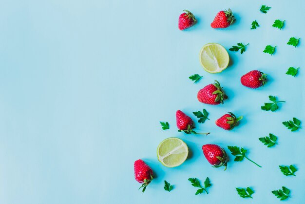 Blauw oppervlak met aardbeien en limes