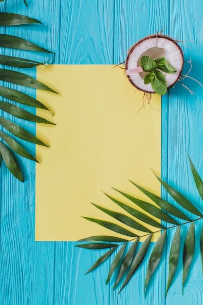 Gratis foto blauw oppervlak met leeg papier en kokosnoot