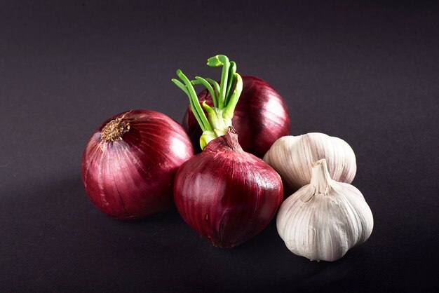 Blauw paarse ui en knoflook geïsoleerd wit op een zwarte