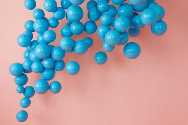 blauwe ballonnen, blauwe bubbels op roze achtergrond. Moderne, punchy pastelkleuren