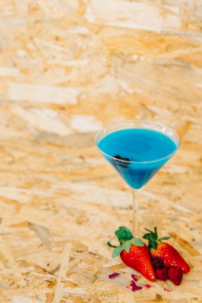 Gratis foto blauwe cocktail en aardbeien