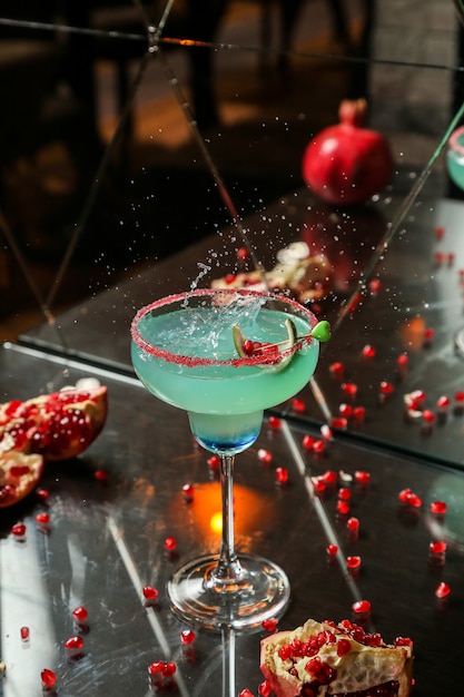 Blauwe cocktail met granaatappel en stroop