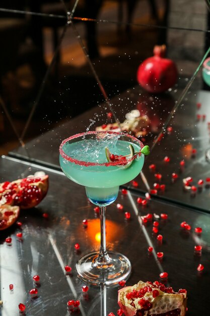 Blauwe cocktail met granaatappel en stroop