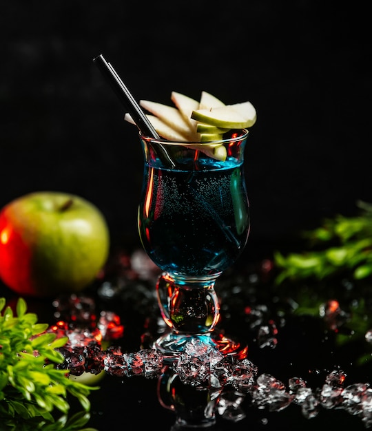 Blauwe cocktail met plakjes appel