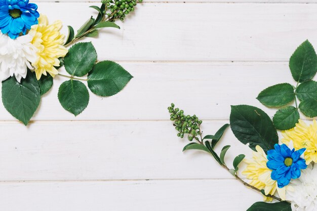 Blauwe en gele bloemen op bladeren