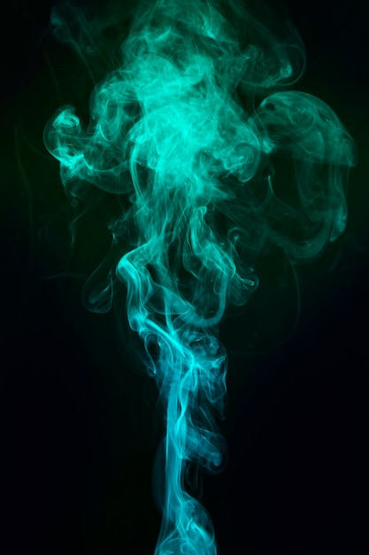 Blauwe en groene rook verspreid over zwarte achtergrond