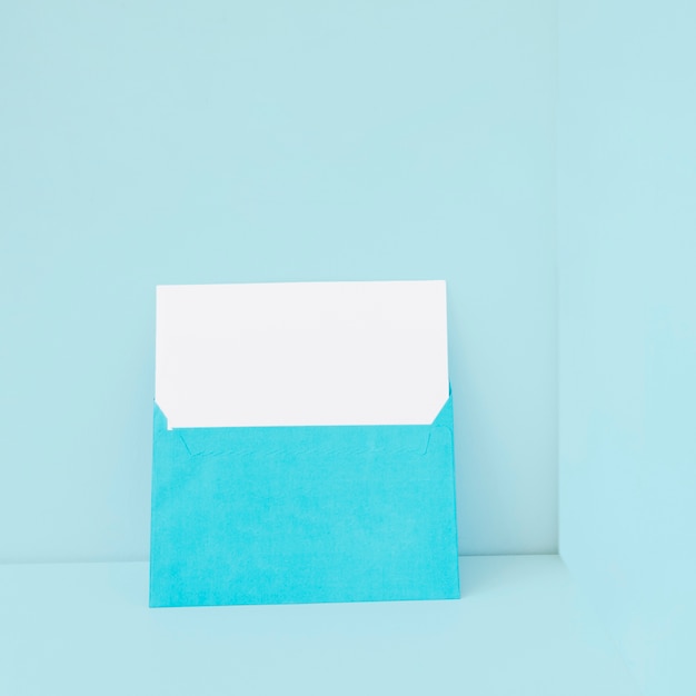 Gratis foto blauwe envelop met leeg papier binnen