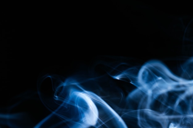 Blauwe golvende rook op zwarte achtergrond