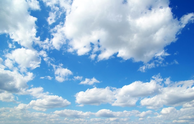 Blauwe hemelachtergrond met kleine wolken
