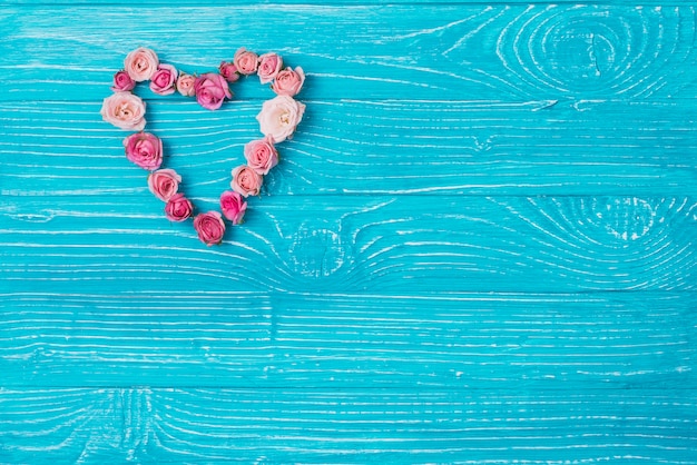 Gratis foto blauwe houten oppervlak met decoratieve bloemen hart