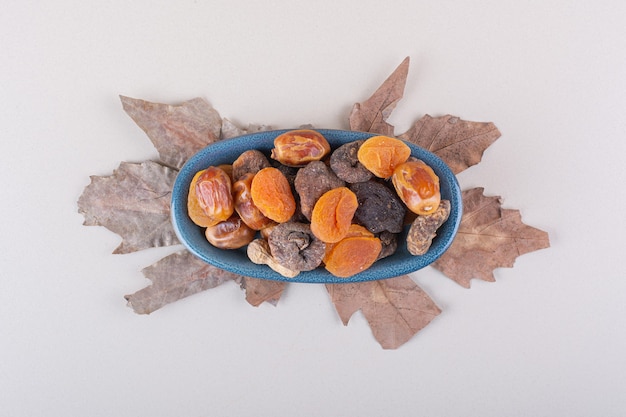 Blauwe kom van verschillende biologische noten en fruit op witte achtergrond. Hoge kwaliteit foto