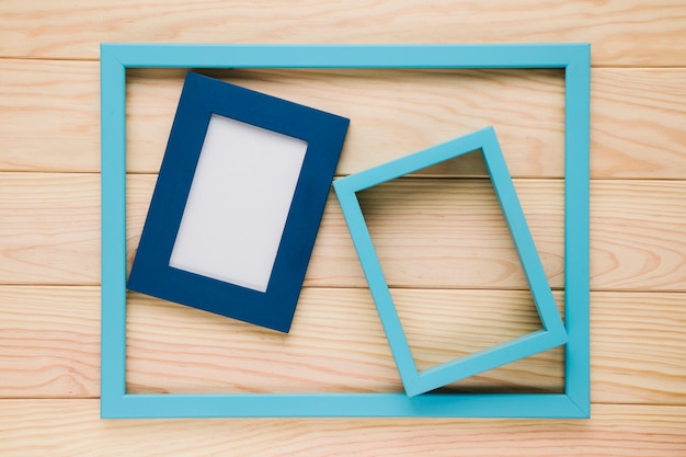 Gratis foto blauwe lege frames op houten achtergrond