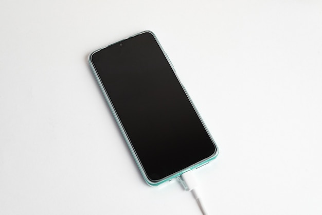 Gratis foto blauwe mobiele telefoon aangesloten op usb-kabel type c - opladen