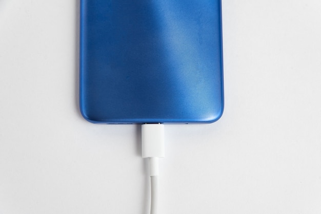 Blauwe mobiele telefoon aangesloten op USB-kabeltype - Opladen