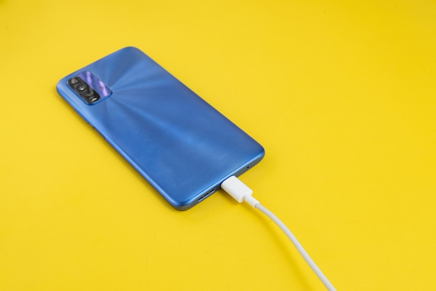 Gratis foto blauwe mobiele telefoon aangesloten op usb-kabeltype - opladen
