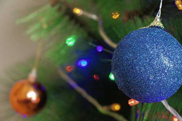 Blauwe ornamentdecoratie op de kerstboom onder de lichten