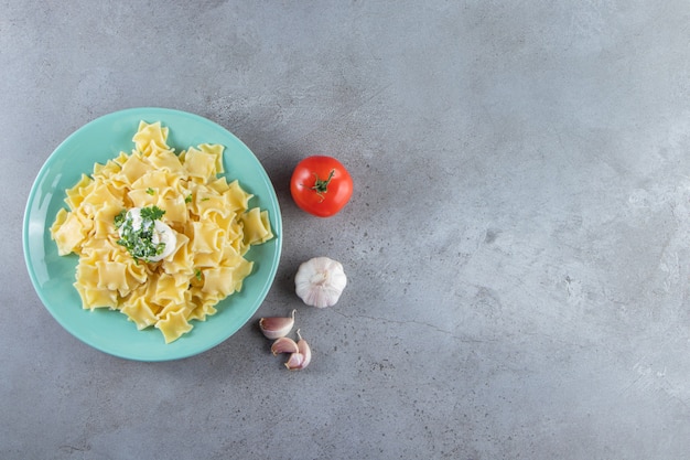 Blauwe plaat van gekookte heerlijke pasta op stenen achtergrond.