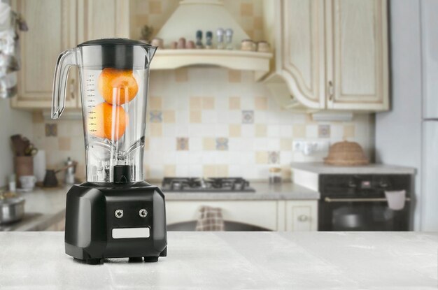 Blender en sinaasappel op houten tafel in de keuken. Maak jezelf fris. Het concept van een gezond dieet