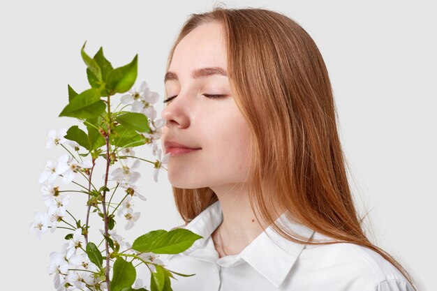 Blij aantrekkelijke vrouw ruikt kersenbloesem