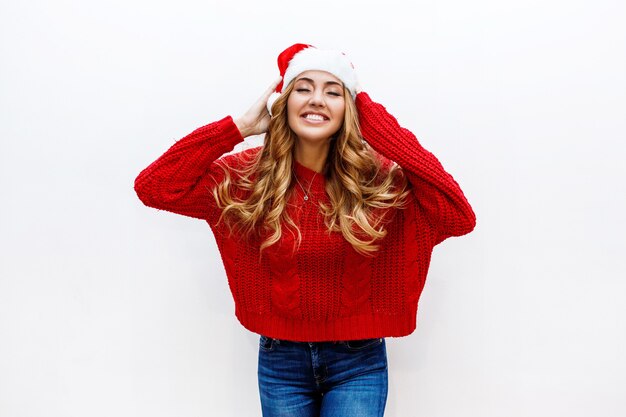 Blij gezicht. Extatische vrouw in rode maskerade nieuwe jaarhoed en sweater