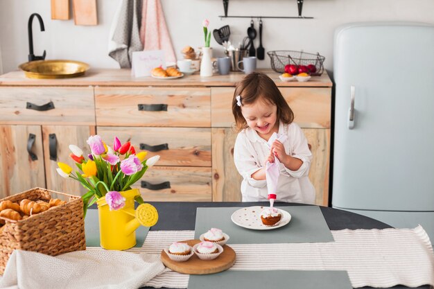 Blij meisje die cupcake maken