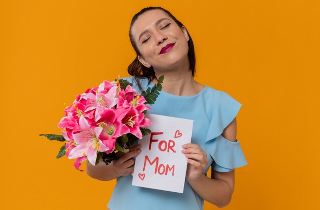 Blij mooie jonge vrouw met boeket bloemen en brief van haar kind