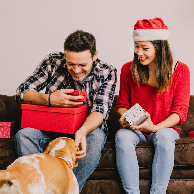 Gratis foto blij paar met hond bij kerstmis