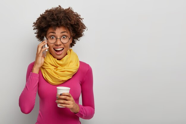 Blij verrast Afro-Amerikaanse vrouw krijgt geweldig nieuws tijdens gesprek via smartphone, heeft koffiepauze