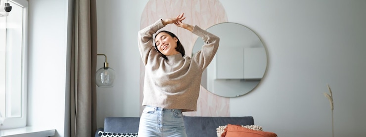 Gratis Foto blije jonge koreaanse vrouw die danst, handen omhoog steekt en er vrolijk uitziet, zich gezond en vrolijk voelt