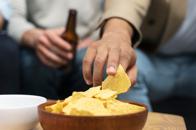 Blije mannen op vrijgezellenfeestje eten snack