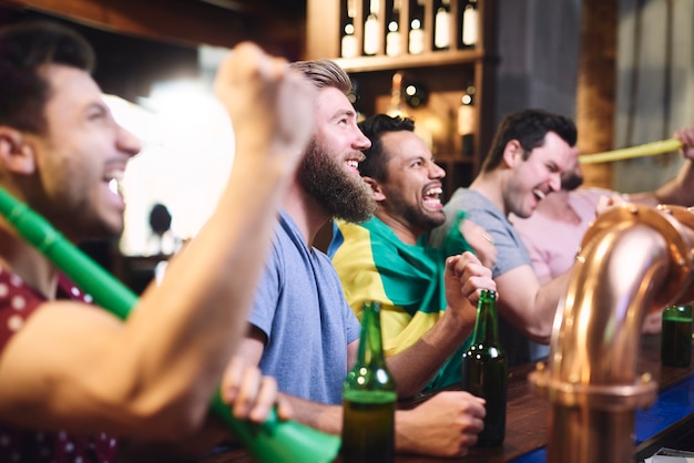 Blije mannen tijdens het kijken naar Amerikaans voetbal