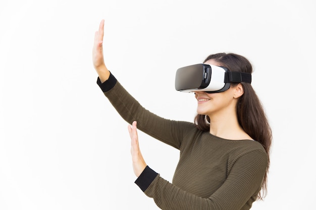 Blije opgewonden vrouw in VR-headset lucht aan te raken