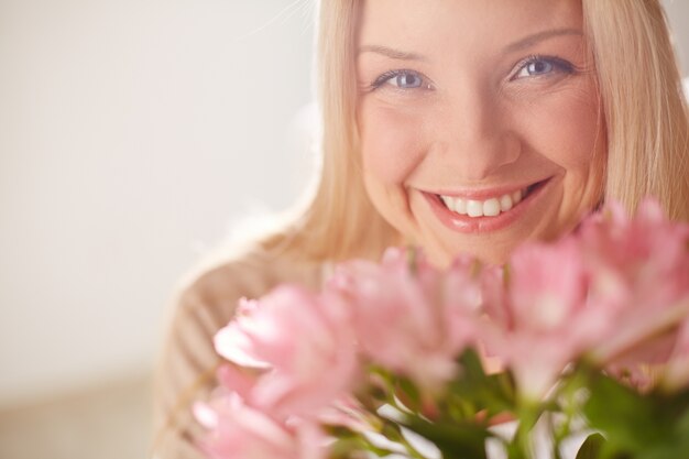 Blije vrouw met roze bloemen