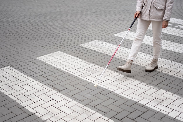 Gratis foto blinde die met blinde stok door de stad loopt