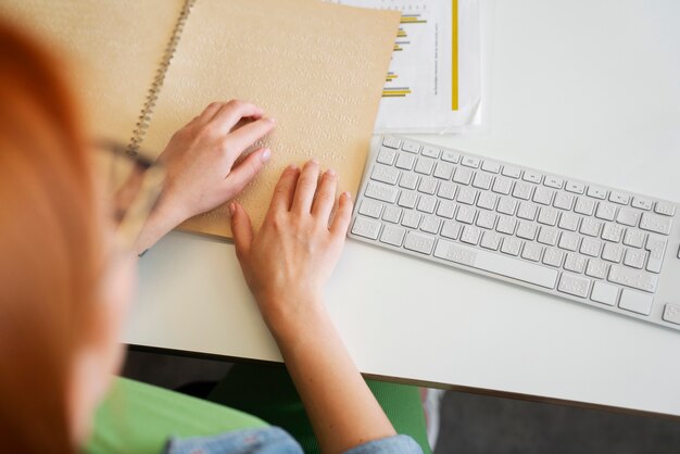 Bling vrouw leest braille bij inclusieve kantoorbaan