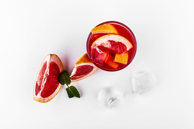 Bloed oranje gin-tonic cocktail geserveerd met plakjes sinaasappel en ijs in een glas