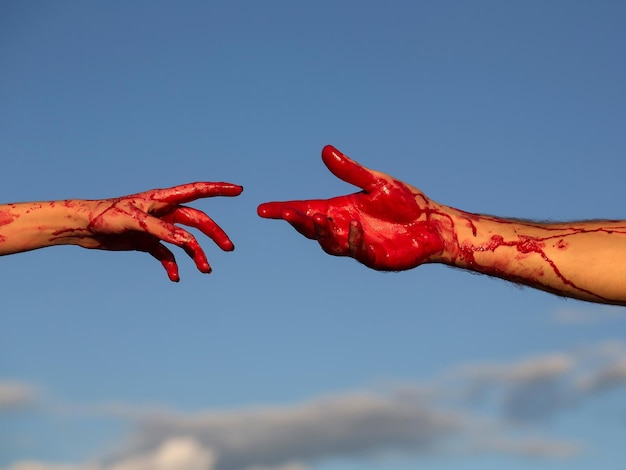 Bloedige zombiehanden met rood bloed op blauwe lucht