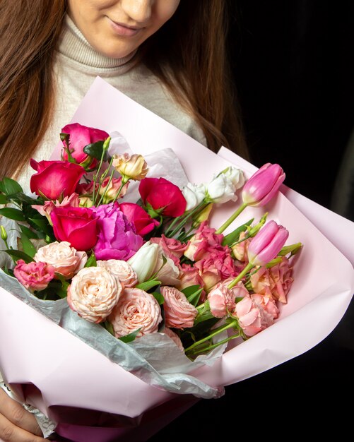 bloemen decor vrouw met boquet van roze rozen, tulpen en rode rozen