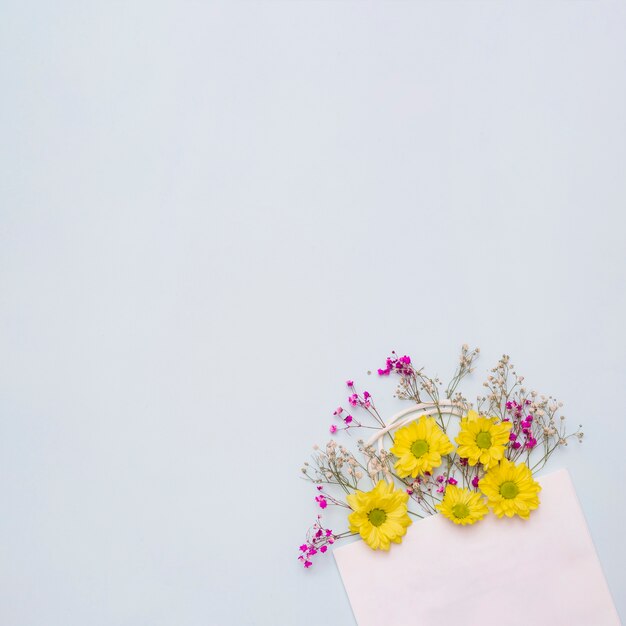 Bloemen die uit de roze document zak komen tegen witte achtergrond