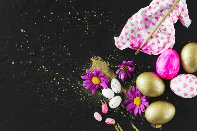 Bloemen en penseel in de buurt van gekleurde eieren