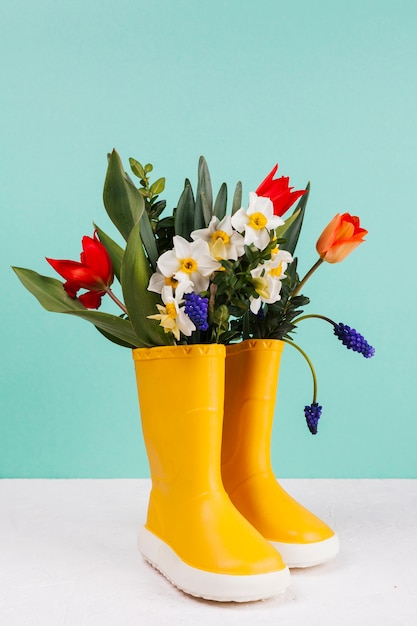 Gratis foto bloemen in een paar gele laarzen