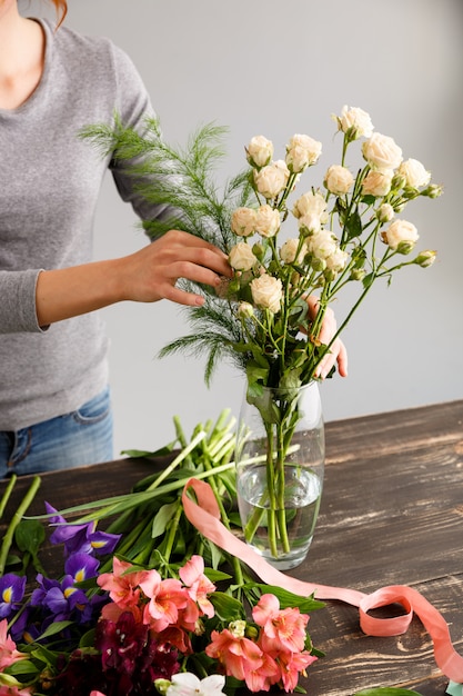 Bloemist die boeketbloemen in vaas maakt