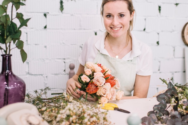 Bloemist met boeket zittend aan tafel