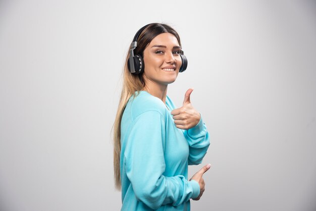 Blond dj meisje luisteren naar de muziek op de koptelefoon en plezier.